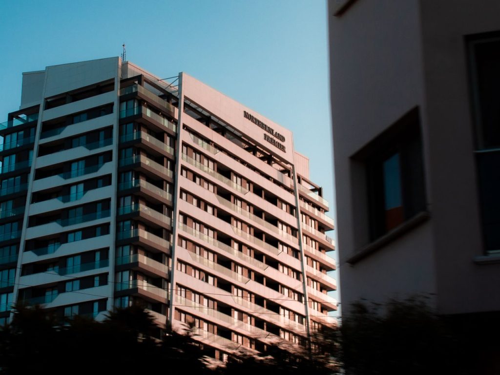 Low angle view of a modern apartment building with balconies, captured during sunset.