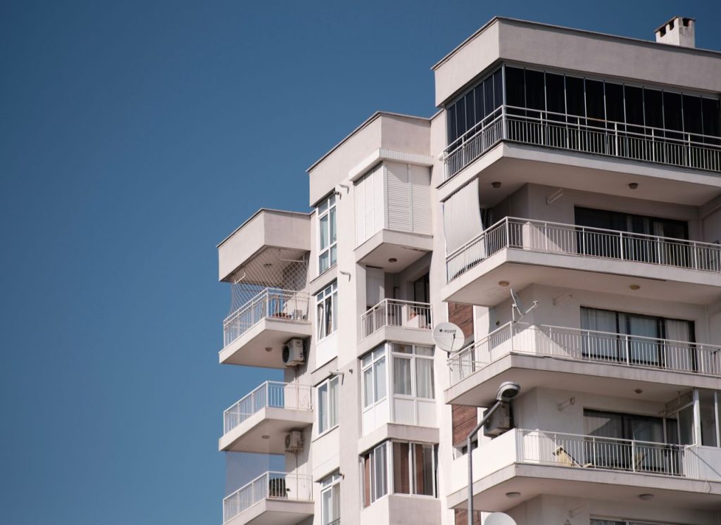 Contemporary apartment building in İzmir under clear blue sky, showcasing modern architecture.