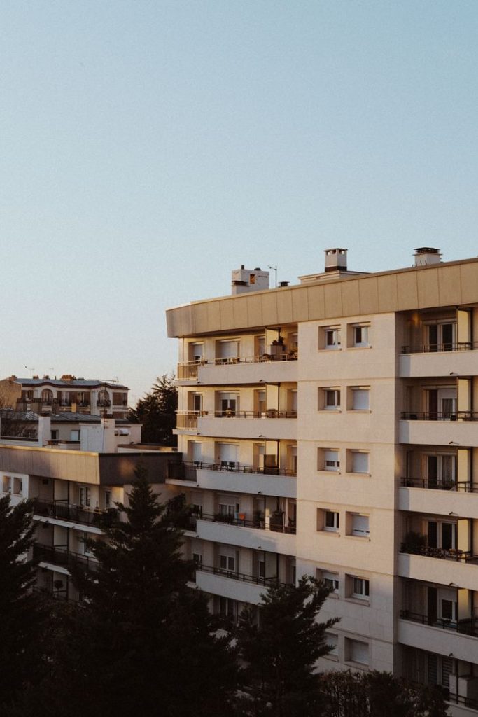 A modern residential building in Paris with a warm sunset glow, capturing the essence of urban living.